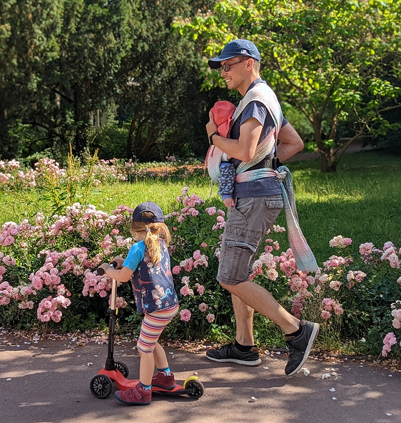 Papa spaziert mit Kind auf dem Roller und Baby in der Trage · Abenteuer Bindung · Sandra Bäthge in Magdeburg